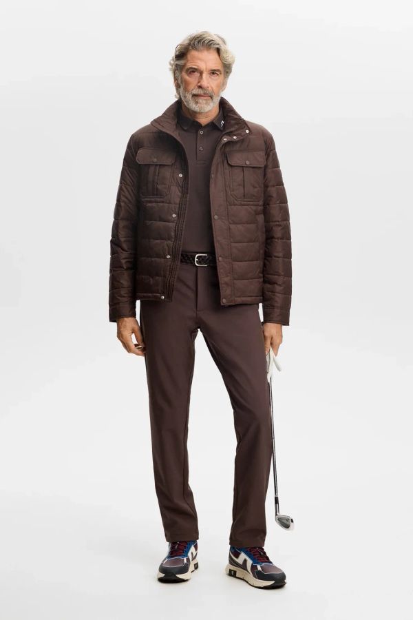 Golfer in a brown padded jacket and matching brown trousers