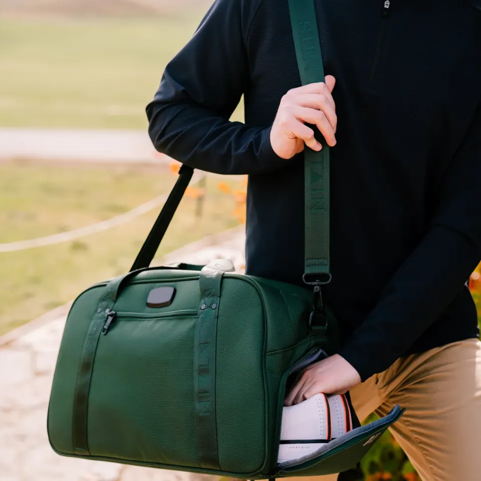 Golfer carrying the Sun Mountain Matchplay Ballistic duffel in green