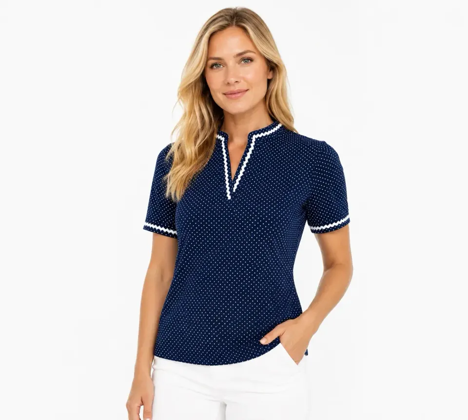 Woman in a navy polka-dot cap-sleeve polo with white trim